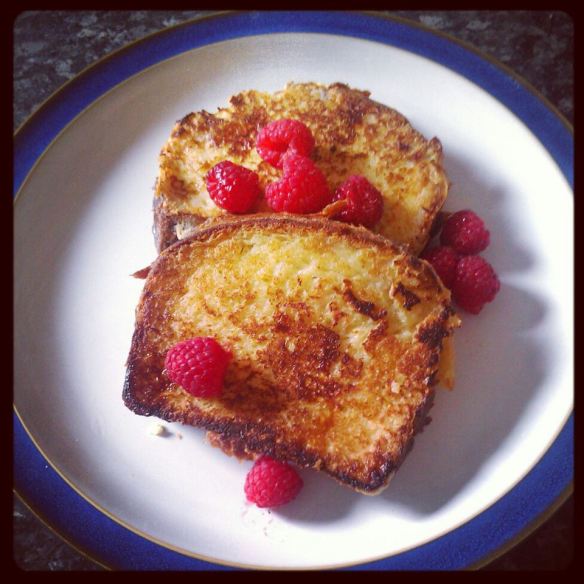 Two slices of brioche French toast with raspberries